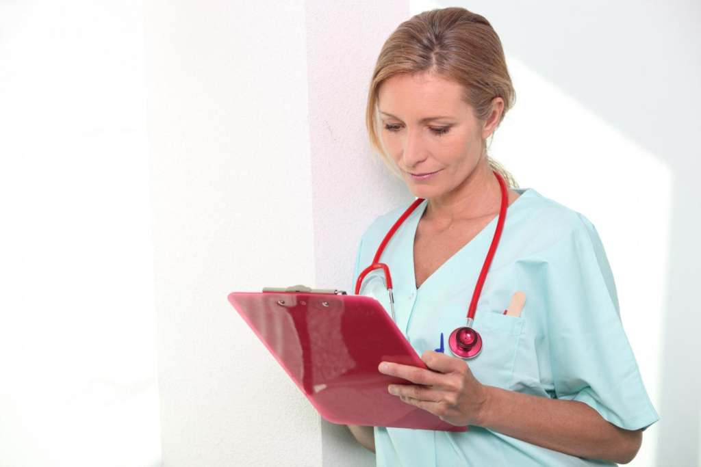 Top Tips for Surviving the Graveyard Shift travel nurse looking at clipboard