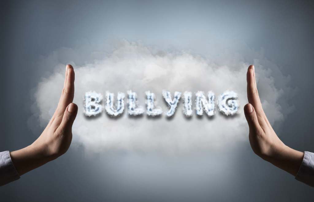 Women showing stop sign with text "BULLYING" (Click for more)