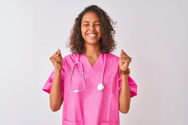 Young brazilian nurse woman wearing stethoscope standing over isolated white background excited for success with arms raised and eyes closed celebrating victory smiling. Winner concept.
