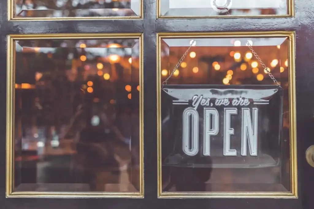 Open vintage sign broad through the glass of store window.