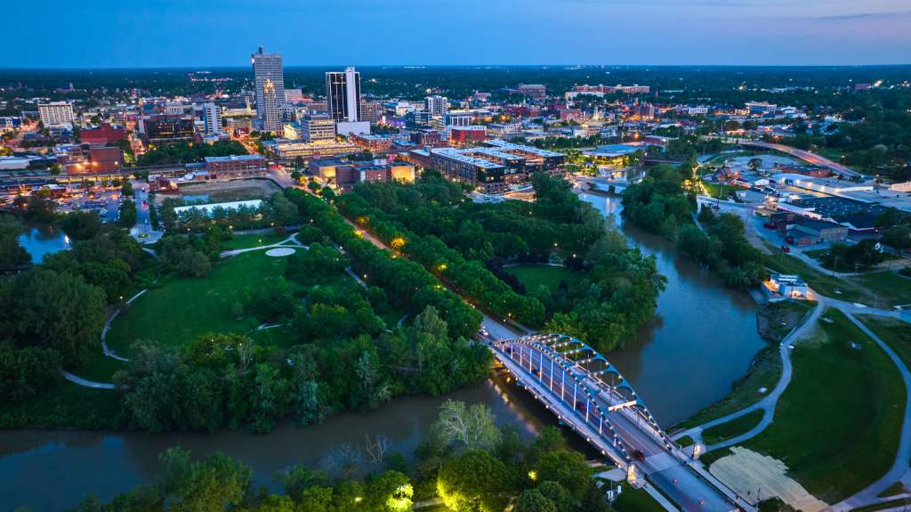 Aerial view of downtown Fort Wayne, Indiana at dusk with city lights and skyline