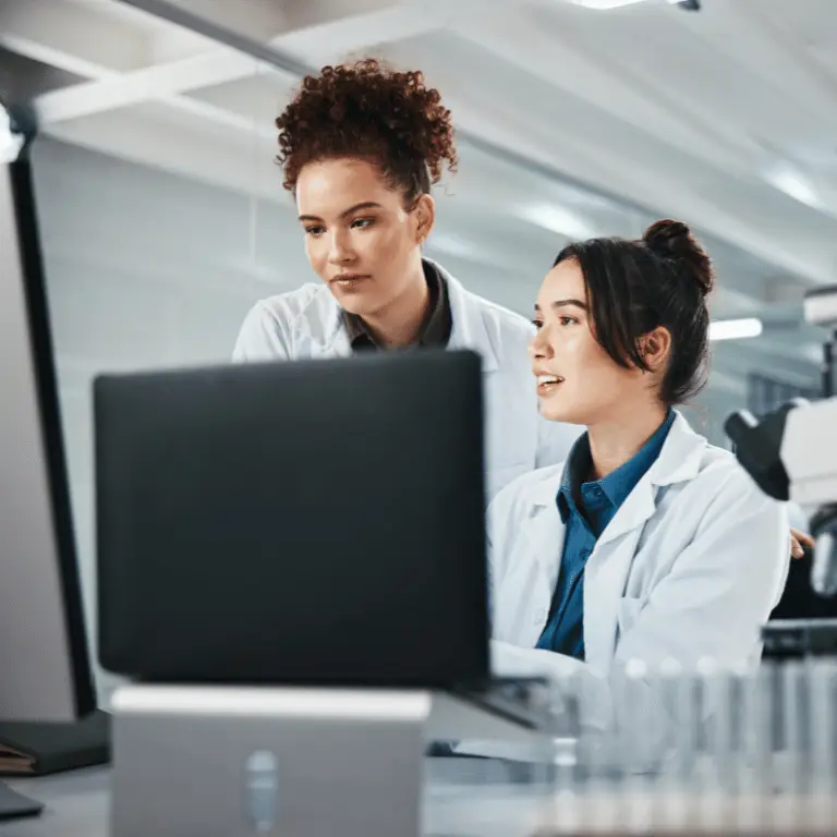 Two life sciences professionals reviewing information on a computer in a laboratory.